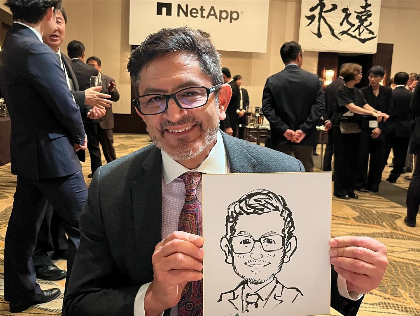 企業パーティーでテーブルを回りながら早描き似顔絵を描く似顔絵師・田村まりり