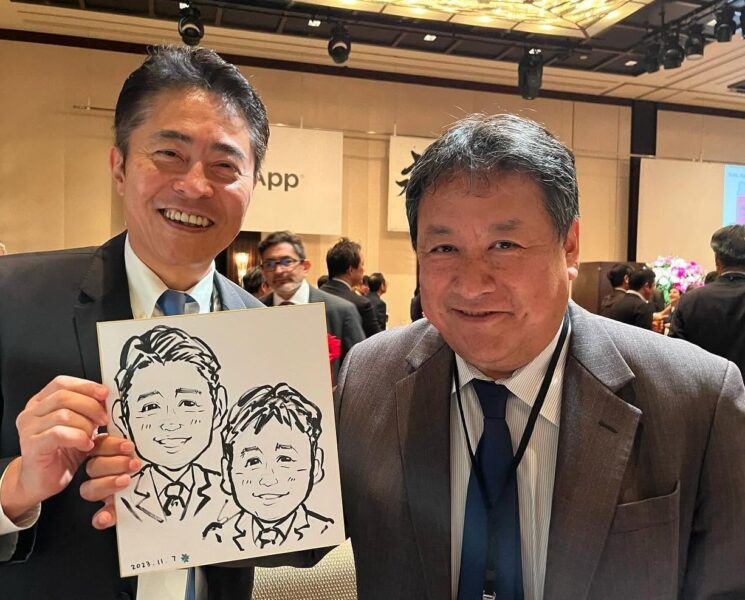 企業パーティーで完成した早描き似顔絵を手に笑顔のお客様